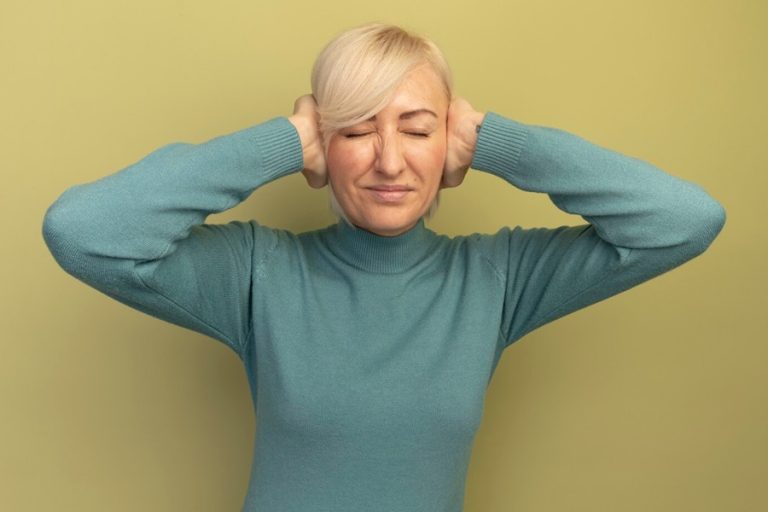 mulher-eslava-loira-bonita-e-desagradavel-fechando-as-orelhas-com-as-maos-em-verde-oliva_141793-69516