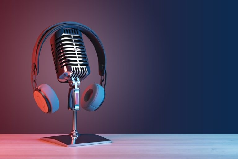 Podcasting and radio concept with retro microphone and headphones on empty wooden table and dark blank wall background with place for your logo or text